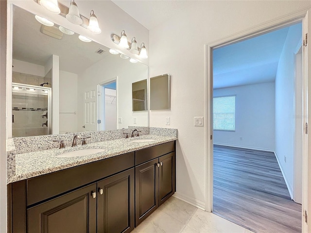 bathroom with vanity, wood-type flooring, and a shower with door