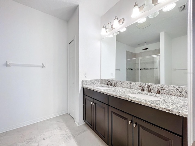 bathroom with a shower with door and vanity