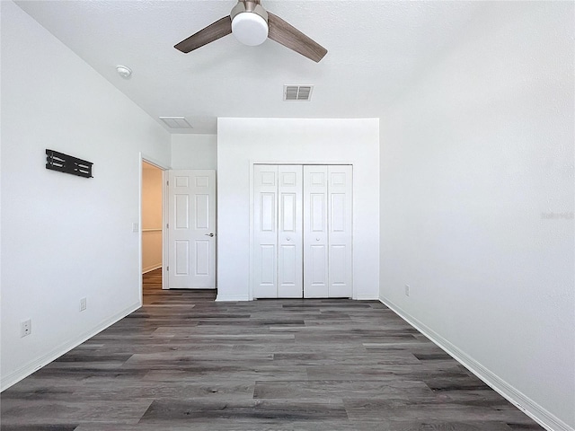 unfurnished bedroom featuring dark hardwood / wood-style flooring, a closet, and ceiling fan