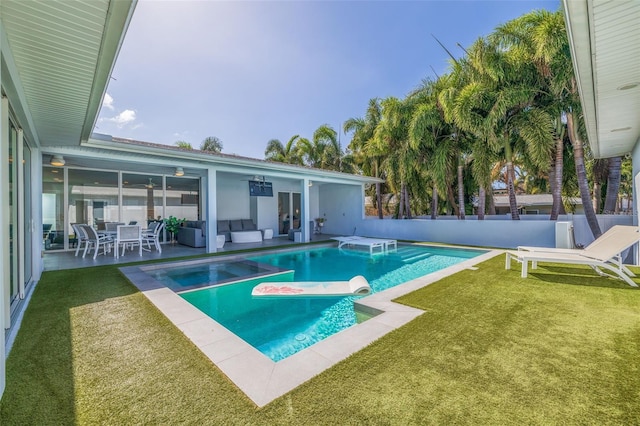 view of swimming pool featuring ceiling fan, a lawn, outdoor lounge area, and a patio area