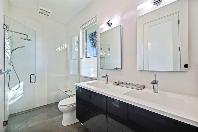 bathroom with toilet, tile patterned floors, vanity, and a shower with door