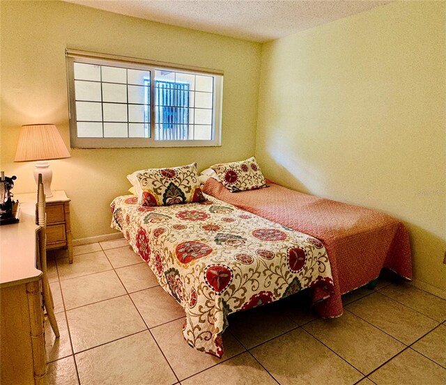 tiled bedroom featuring a textured ceiling