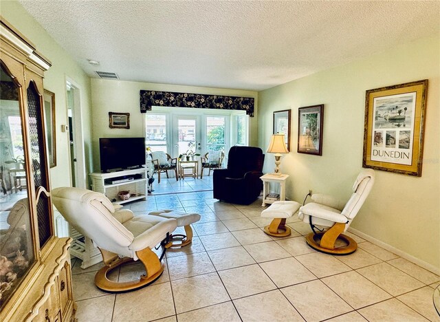 living room with a textured ceiling and light tile patterned floors