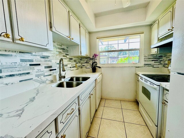 kitchen featuring backsplash, sink, light tile patterned flooring, and white appliances