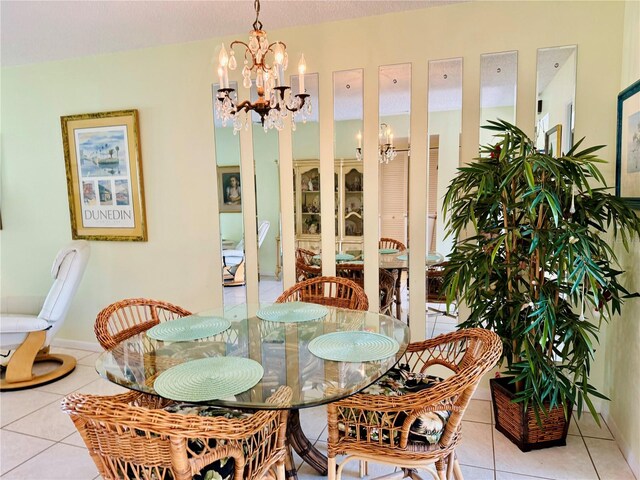 dining area featuring light tile patterned floors and an inviting chandelier