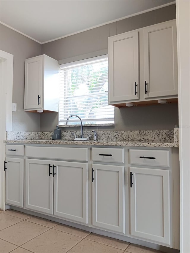 kitchen with ornamental molding, white cabinets, and light tile patterned floors