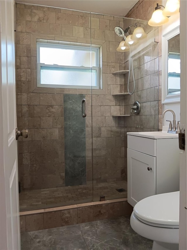 bathroom featuring vanity, toilet, and a shower with shower door