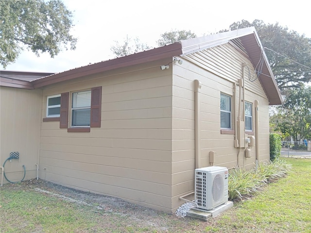 view of home's exterior with ac unit and a lawn