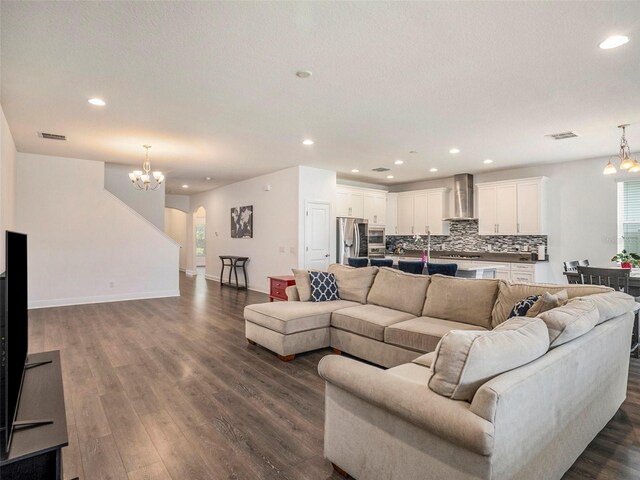 living room featuring a notable chandelier, dark hardwood / wood-style floors, and a textured ceiling