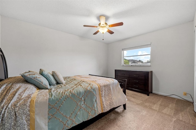 carpeted bedroom featuring ceiling fan and a textured ceiling