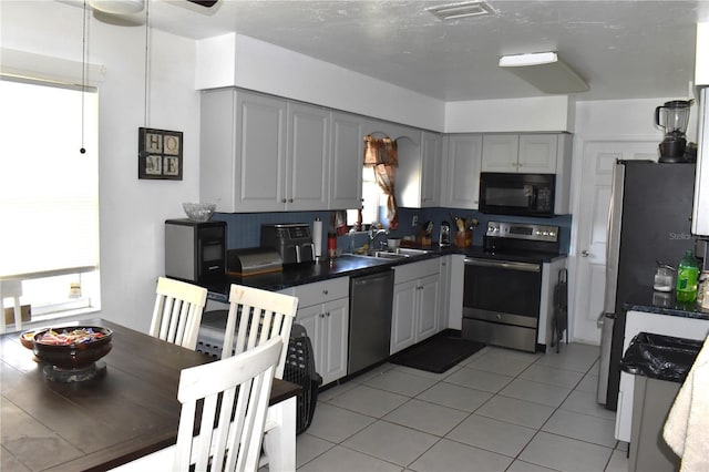 kitchen featuring sink, light tile patterned flooring, gray cabinetry, and stainless steel appliances