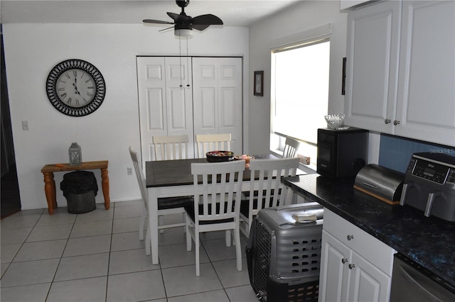 dining space with lofted ceiling, light tile patterned flooring, and ceiling fan