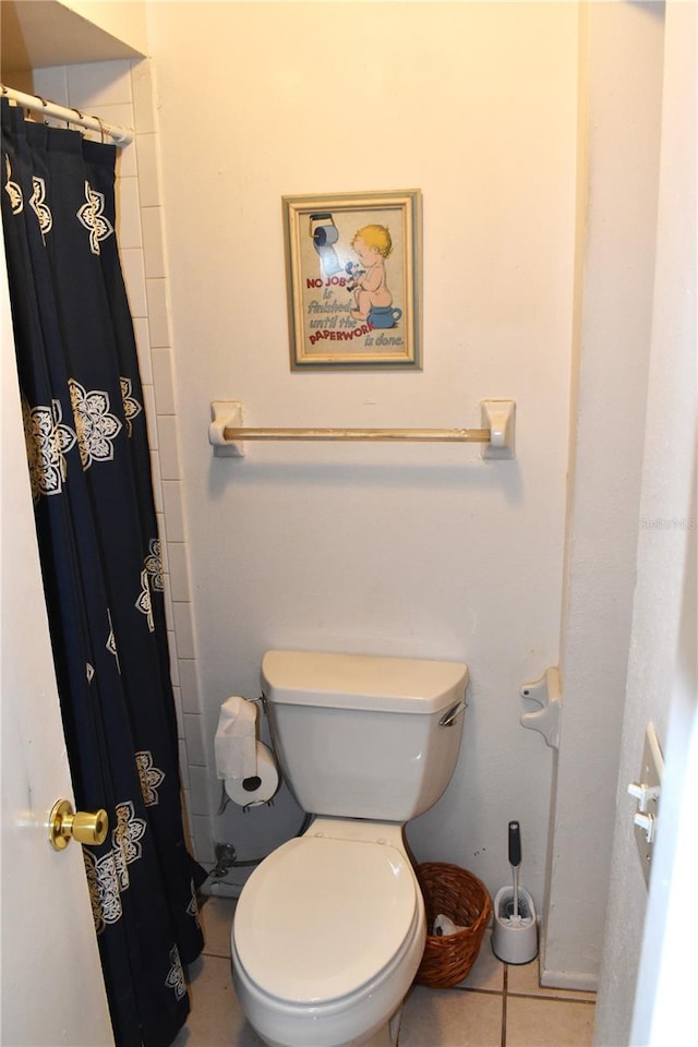 bathroom featuring a shower with shower curtain, toilet, and tile patterned flooring