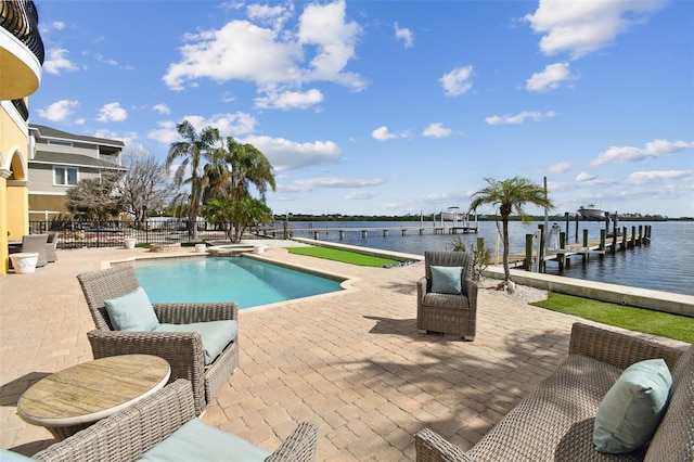 view of swimming pool featuring a dock, a water view, and a patio