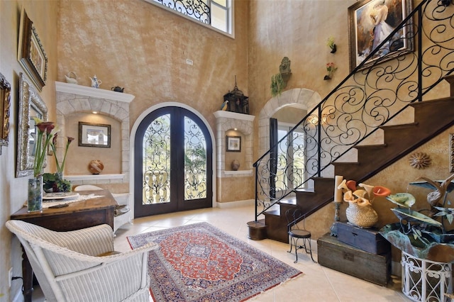 entrance foyer featuring light tile patterned floors, french doors, and a high ceiling