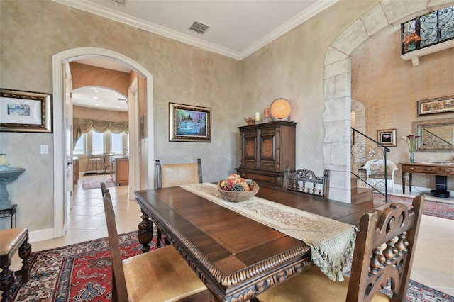 dining space featuring light tile patterned flooring and crown molding