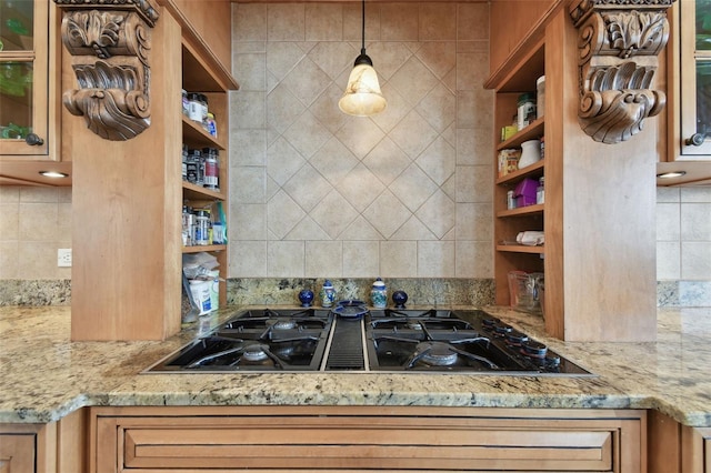 kitchen with black gas stovetop, decorative light fixtures, decorative backsplash, and light stone counters