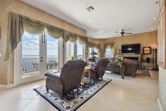 living room with ceiling fan, light tile patterned flooring, a water view, and french doors