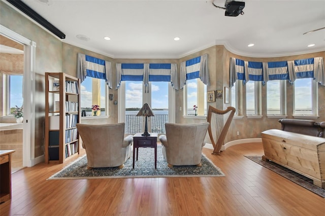 living area featuring ornamental molding and hardwood / wood-style flooring