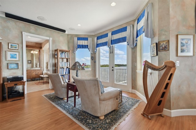 sitting room featuring hardwood / wood-style floors, ornamental molding, and french doors