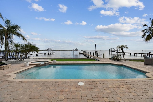 view of swimming pool with a water view, a dock, and an in ground hot tub