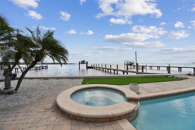 view of pool with a water view, a boat dock, and an in ground hot tub