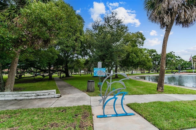 view of home's community featuring a lawn and a water view