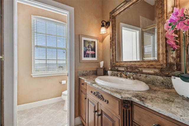 bathroom with toilet, tile patterned flooring, and vanity