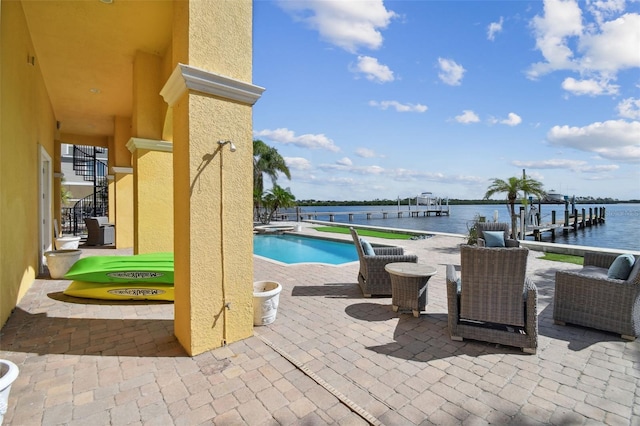 view of swimming pool with a patio, a water view, and a boat dock