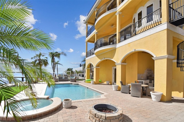 view of pool with an outdoor fire pit, a patio area, and an in ground hot tub