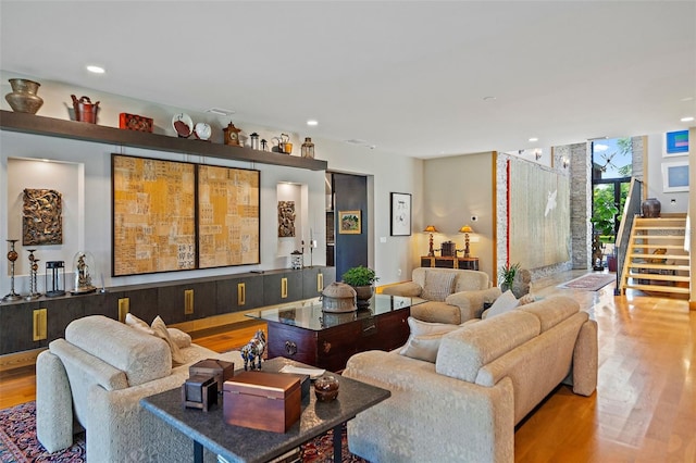 living room with a wall of windows and light hardwood / wood-style floors