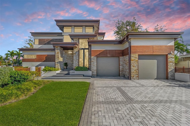 contemporary house featuring a lawn and a garage