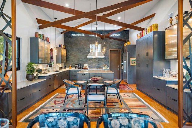 kitchen featuring high vaulted ceiling, light hardwood / wood-style floors, and pendant lighting