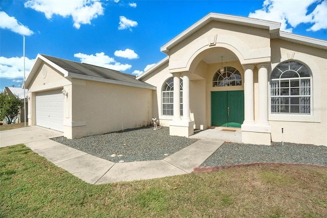 property entrance featuring a lawn and a garage