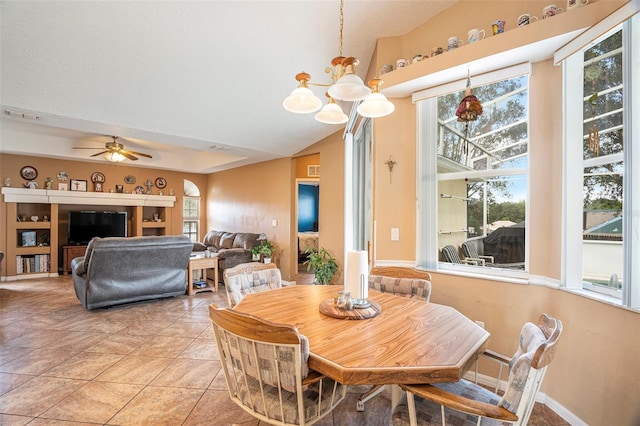 dining area with lofted ceiling, ceiling fan with notable chandelier, and light tile patterned floors