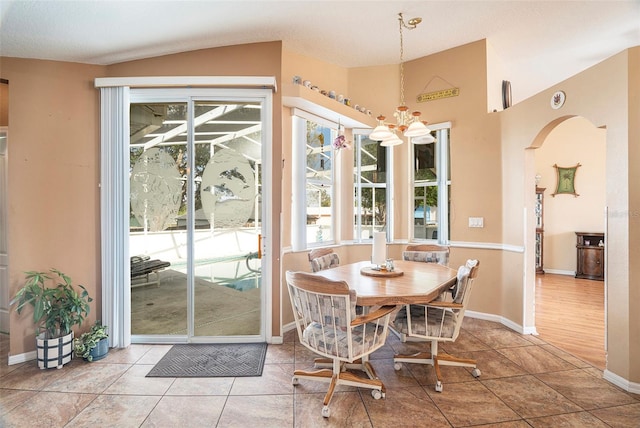 dining space featuring lofted ceiling, hardwood / wood-style floors, a textured ceiling, and a notable chandelier