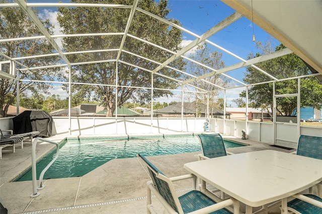 view of pool with a patio area, area for grilling, and glass enclosure