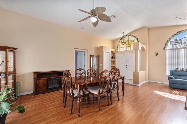 dining space with high vaulted ceiling, hardwood / wood-style floors, a textured ceiling, and ceiling fan