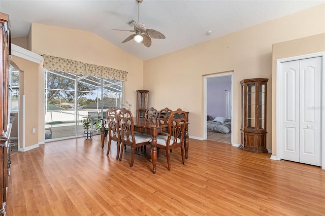 dining room with ceiling fan, lofted ceiling, and light hardwood / wood-style flooring