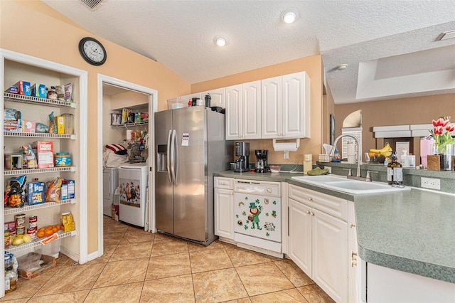 kitchen with stainless steel refrigerator with ice dispenser, sink, white dishwasher, independent washer and dryer, and white cabinets