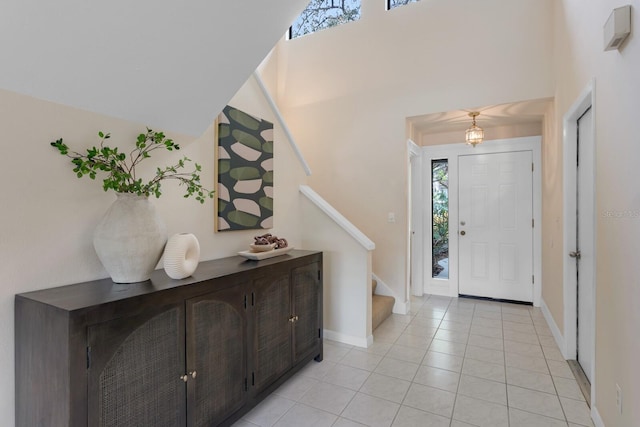 entryway featuring light tile patterned flooring and a high ceiling