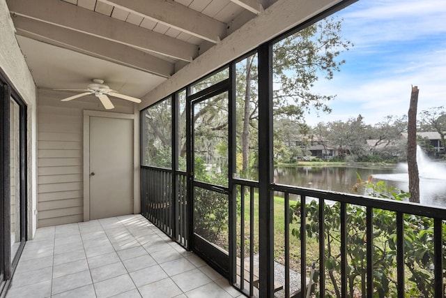 unfurnished sunroom with beamed ceiling, a water view, and ceiling fan