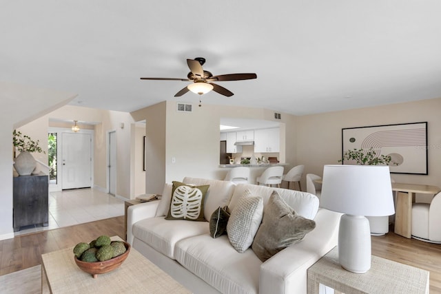 living room featuring ceiling fan and light wood-type flooring