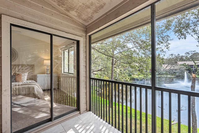 unfurnished sunroom featuring a water view and vaulted ceiling