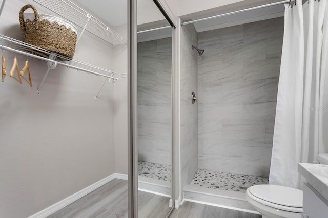 bathroom featuring vanity, hardwood / wood-style floors, curtained shower, and toilet