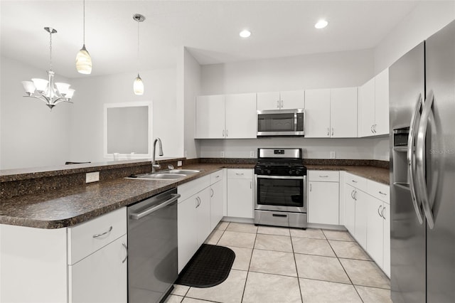 kitchen featuring light tile patterned flooring, sink, appliances with stainless steel finishes, white cabinets, and pendant lighting