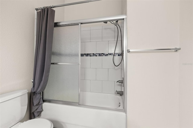 bathroom featuring tiled shower / bath and toilet