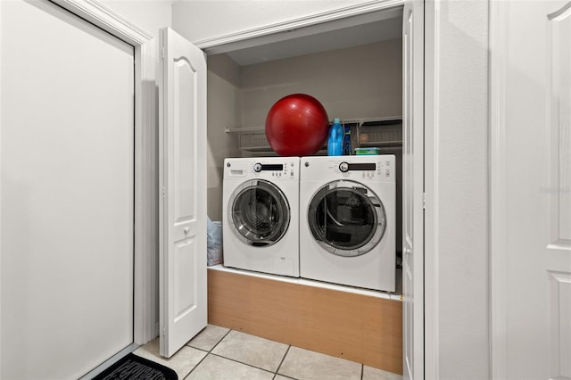 washroom featuring washer and clothes dryer and light tile patterned floors