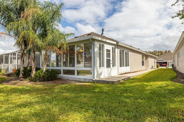 back of property featuring a sunroom and a yard