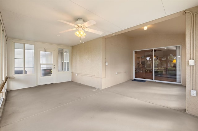 unfurnished sunroom with ceiling fan and vaulted ceiling